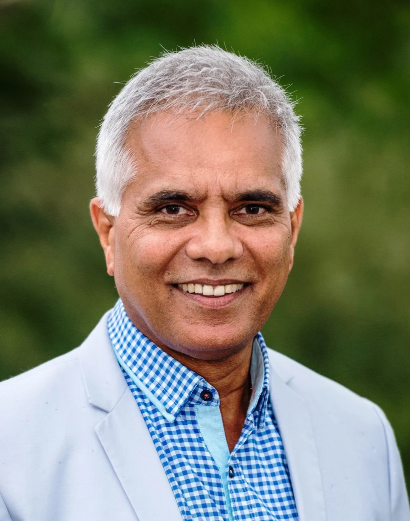 Dr Jonathan Toussaint in a light blue jacket and checked shirt
